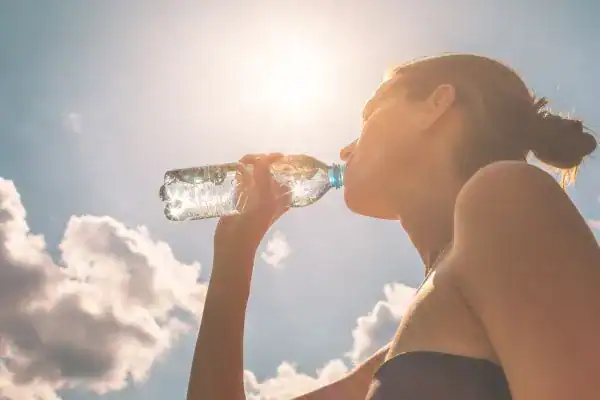 Hydration: The Secret Ingredient for a Toned Stomach and Enhanced Fitness 3 Image of woman drinking water to hydrate Walsall after run.