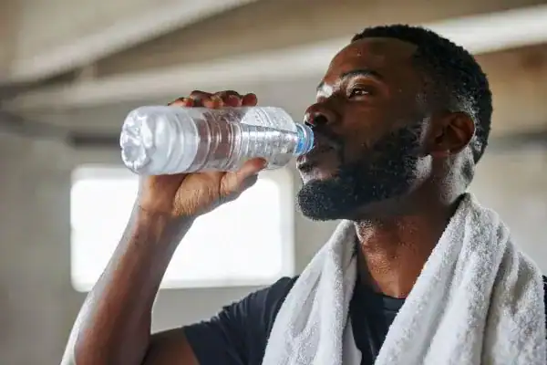 Hydration: The Secret Ingredient for a Toned Stomach and Enhanced Fitness 1 Image of man drinking water to improve hydration Walsall after work out.